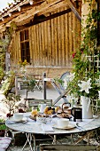 Outdoor table set for afternoon coffee in front of old barn