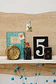 Vintage ornaments on bookshelf; animal-motif postage stamps, decorative book cover, toy deer, X and 8 printing blocks and 60s Junghans alarm clock
