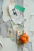 Postage stamps, everlasting flower, printed Oriental paper and washi tape decorating wooden wall with extremely weathered paint