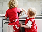 Zwei kleine Mädchen backen in der Küche