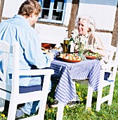 A couple eating lunch in the garden, Skane, Sweden.