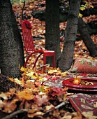 A Red Chair among Autumn Leaves