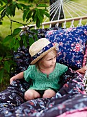 Girl wearing straw hat on hammock