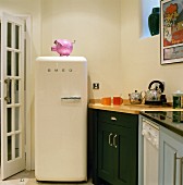 Frei stehender Kühlschrank im Retrostil neben verschiedenen Unterschränken in einer Küche