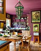 Violett getöntes Esszimmer mit traditionellem Holztisch und Gedecken