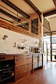 Modern kitchen counter below gallery with metal balustrade in renovated farmhouse