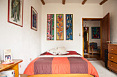 Schlafzimmer mit Holzbalken und Bildern an der Wand