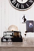 Vintage decor on concrete desk; fashion pictures and wall clock on white wood panelling