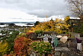 Autumnal terrace with rustic dining table and view across Norwegian skerry coast
