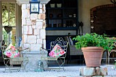 Nostalgic seating area in front of open, country-house kitchen in summer ambiance