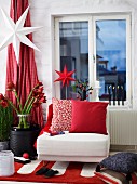 Weihnachtlich geschmücktes Wohnzimmer mit Sessel vor Fenster