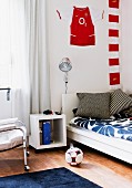 Boy's bedroom with bed, bedside cabinet and football-themed decor