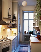 Blick in längliche Küche mit weissen Küchenmöbeln