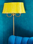 Antique, yellow standard lamp against blue living room wall