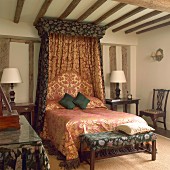 Canopied bed decorated with traditional fabrics in old half-timbered house