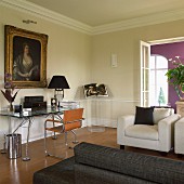 Modern, designer furniture in living room with gilt-framed portrait of woman