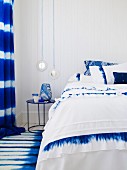 Blue and white bedroom with double bed, bedside table, rug & curtains
