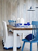 Blue and white dining room with wooden table & various chairs