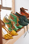Coloured leather shoes on shoe rack