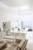 Classic couch and coffee table in front of dining area with white chairs in open-plan interior