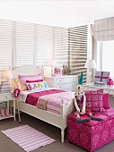Bright girl's bedroom with white furniture and cheerful pink accents