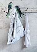 Birds painted on wall rack and simple, white laundry bag decorated with poetry