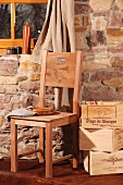 Stacked wooden crates of books next to hand-crafted chairs with backrest made from side of wine crate