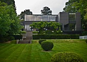 Box balls in garden with terraces and steps leading to Bauhaus-style house
