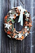 Festive decorative wreath made of pieces of bark on wooden wall