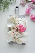 Stoffservietten & Besteck dekoriert mit Stoffband & Wickenblüte