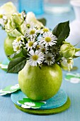 Green apple used as vase for posy