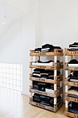Stacked fruit crates used as creative shelves for clothing in loft-style bedroom