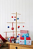 Christmas tree made from wooden rods decorated with blue, red & white baubles