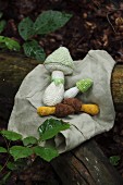 Gehäkelte Pilze auf Tuch im Wald