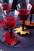Wine glasses decorated with colourful, painted autumn leaves