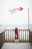 Girl standing on deck near ocean