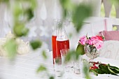 Limonade mit Gläsern & Rosendeko auf Tisch in Pavillon