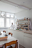 Heller Essbereich mit rustikalem Holztisch und offenen Regalen in einer Küche