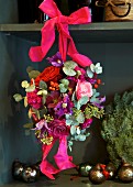 Spherical flower arrangement with roses tied to shelf with silk ribbon