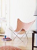 Butterfly chair with Moroccan-style pattern; floor cushion with same pattern in foreground