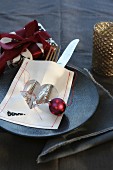 Christmas place setting with sewn parchment cutlery bag, tree bauble and wrapped present