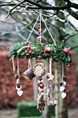Decorative, wreath-shaped feeder for native birds hanging from branch
