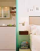 Schlafzimmer mit Abtrennung durch Glasschiebeelemente zur angrenzenden Küche