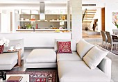 White furnishings in open-plan living area in designer apartment