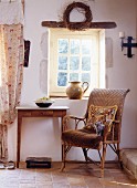 Kitten and tapestry cushion on wicker chair below lattice window in historical, French farmhouse