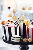 Wooden beads on toothpicks in striped cupcake cases of liquorice allsorts