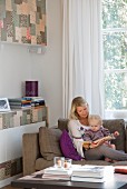 Mother and toddler reading on a sofa; wall of fitted cupboards to one side with patchwork-patterned fronts
