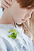 Girl with sprig of lady's mantle pinned to dress