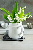 Posy of lily of the valley in white china jug