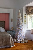 White and gold romantic Christmas tree and wrapped presents in faux-antique girl's bedroom